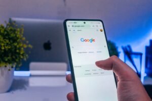 una mano tiene un cellulare e cerca giardiniere a latina su google